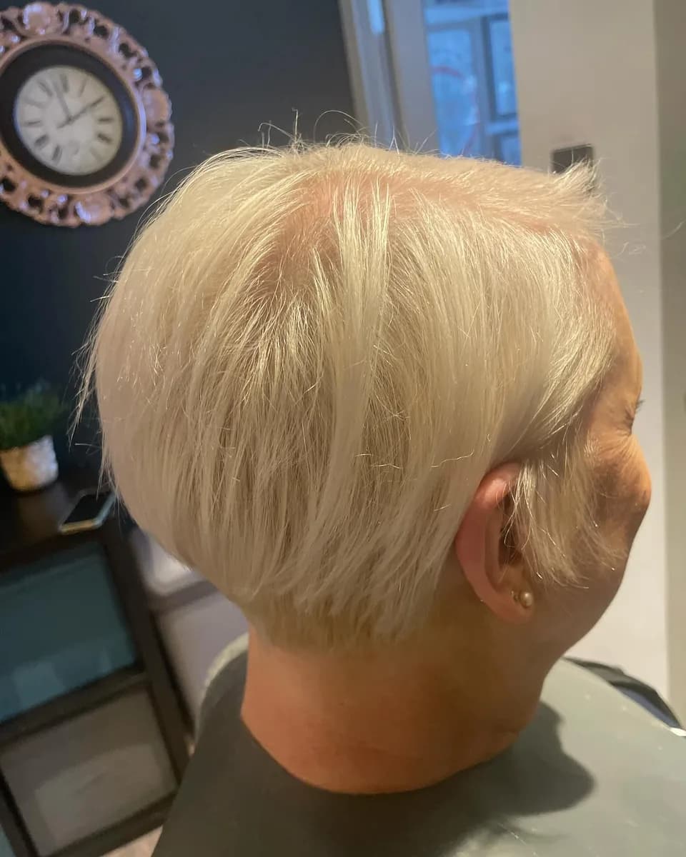 A short blonde pixie cut, cropped close at the neck