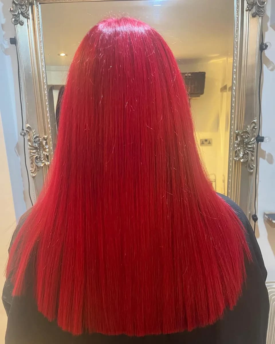 A vivid red on long hair, finished sleek and shiny